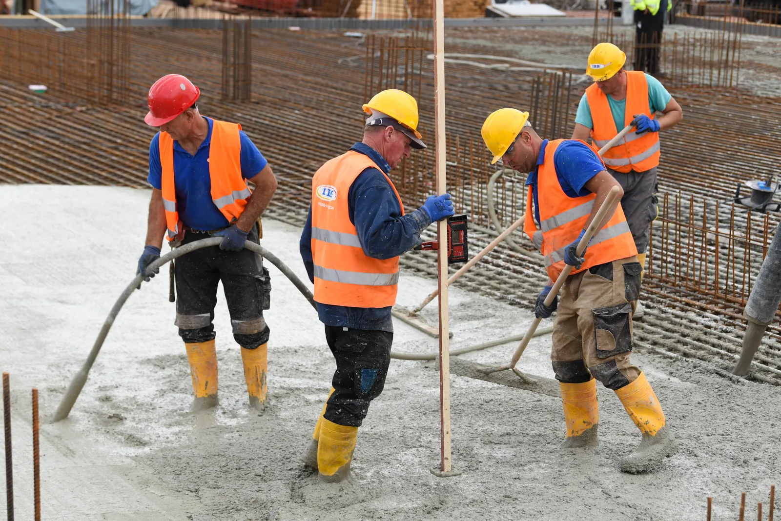 Crew pouring and levelling a concrete slab