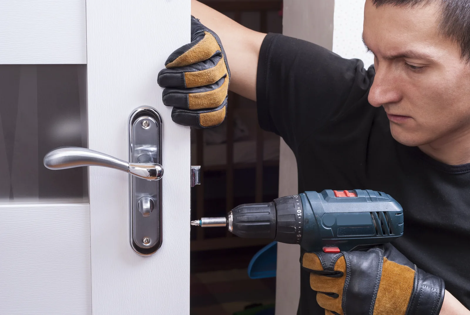 A door handle and lock being fitted to a timber door