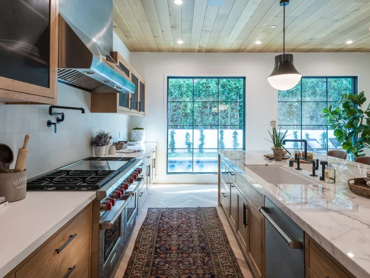 A finished kitchen with timber cabinetry and stone benchtops