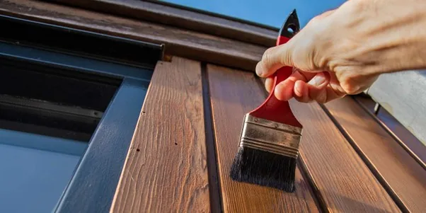 A painter rolling fresh paint onto an interior wall