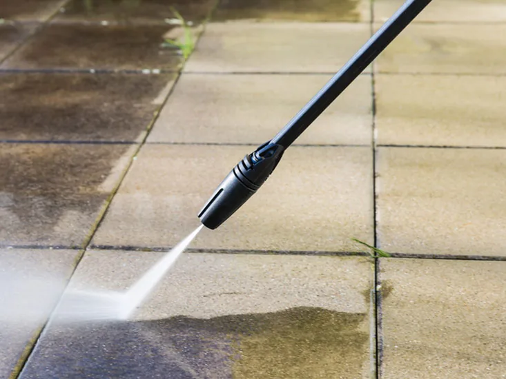 Pressure washing a paved surface as part of scheduled maintenance